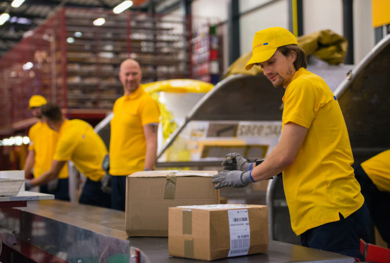 Postal Workers Sorting Packages On A Conveyor Belt DTC Jobs